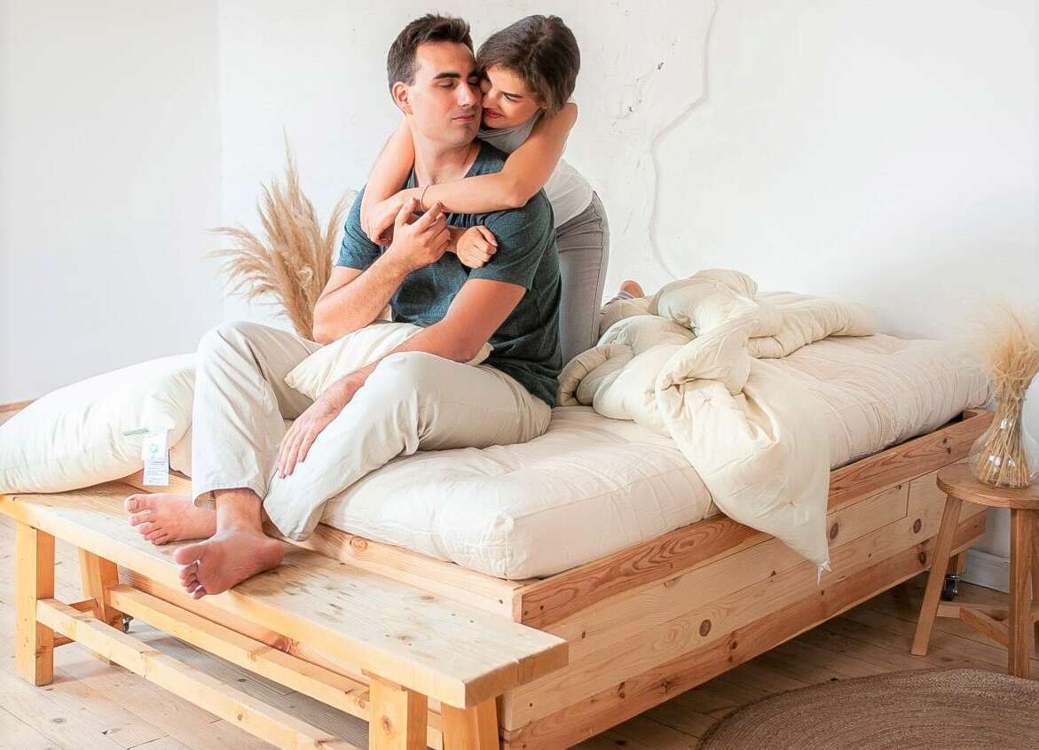 Couple sitting on a wooden bed
