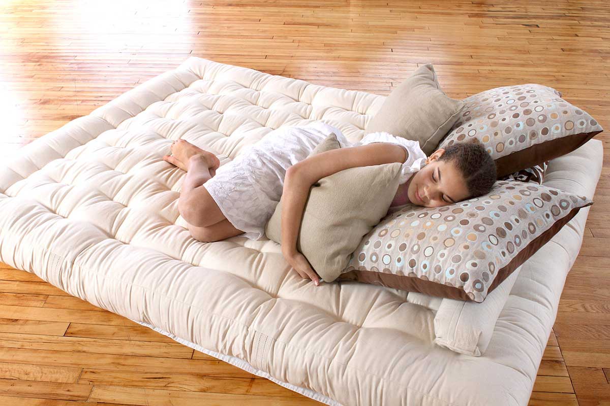 Girl sleeping on a tufted floor mattress