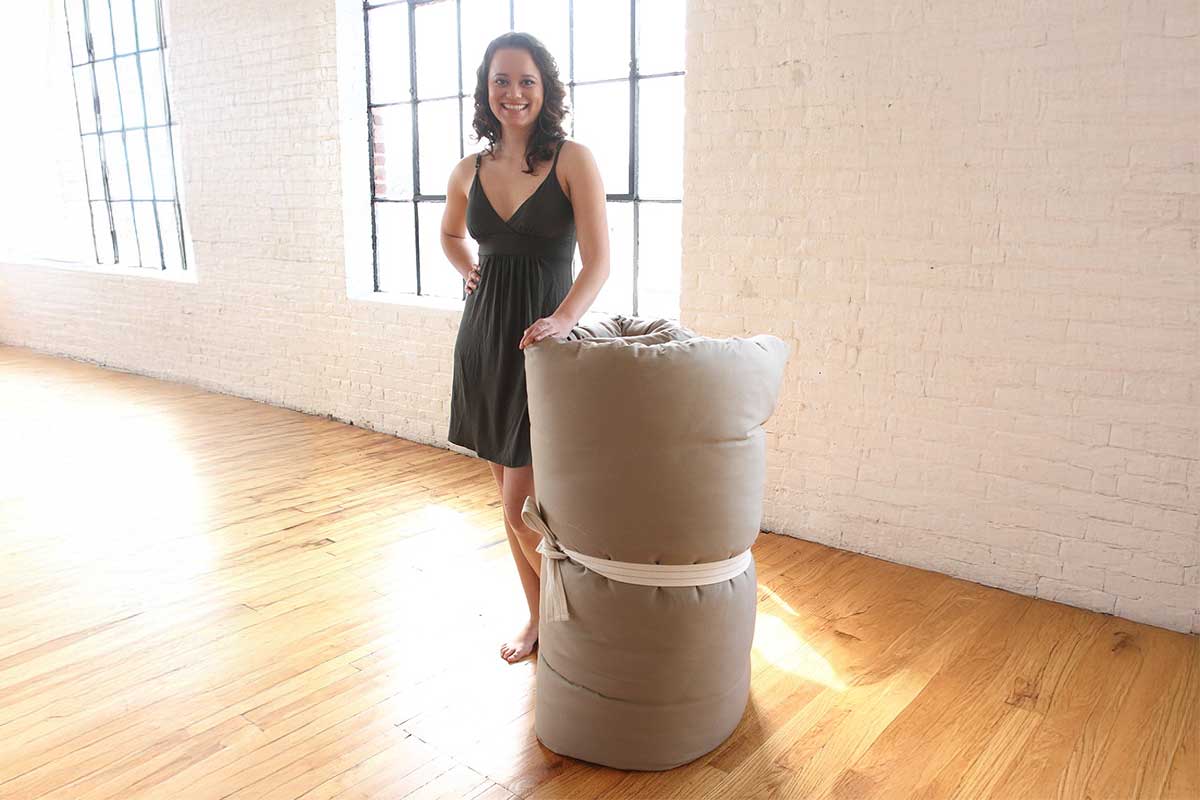 Woman with a rolled mattress