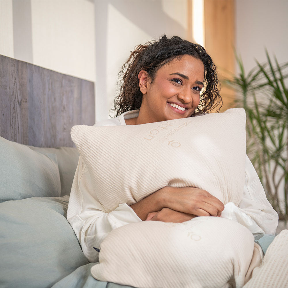 Woman holding a pillow in a cozy living room setting